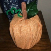 A decorative pumpkin created from a toilet paper roll.