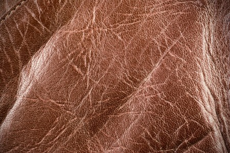 Close up of an old brown leather couch.