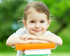 A girl leaning on her school books.