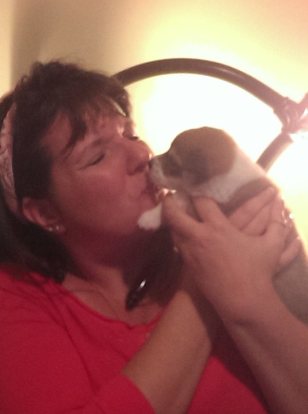 Woman kissing puppy.