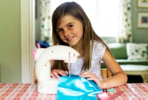 A girl sewing with a sewing machine.