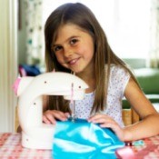 A girl sewing with a sewing machine.
