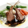 A plate of lamb chops and carrots.