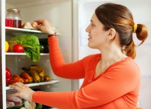 A woman looking in the refrigerator.
