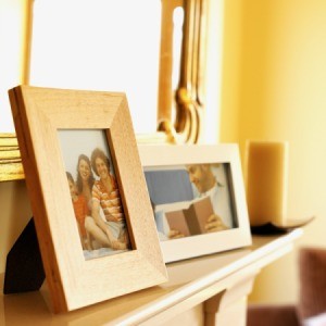 Framed family photos sitting on a shelf.