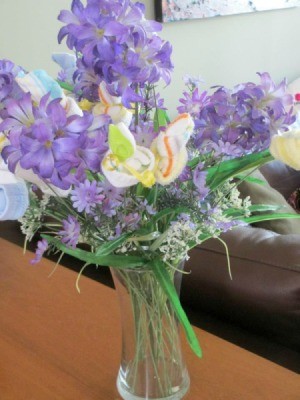 Vase of artificial flowers and baby socks.