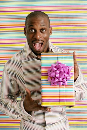 A 30 year old man holding a gift.