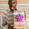 A 30 year old man holding a gift.