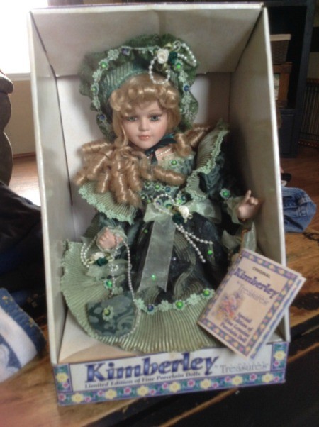 Doll dressed in green period clothing.