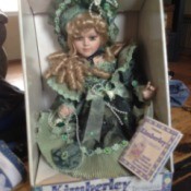 Doll dressed in green period clothing.