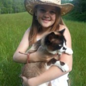 Young girl holding cat.