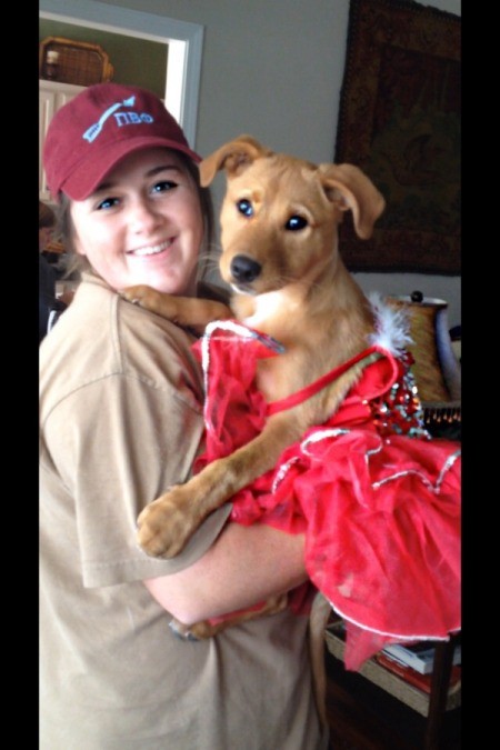 Young woman holding a yellow dog.