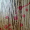 Red wax stains on wood floor.