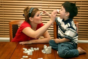 Teen Babysitter Playing Dominoes with Child
