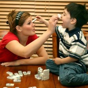 Teen Babysitter Playing Dominoes with Child