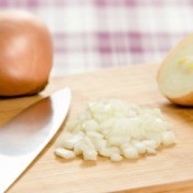 Onions being chopped on a cutting board.