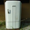 Old worn white metal refrigerator.