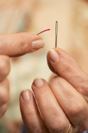 Woman Threading a Sewing Needle