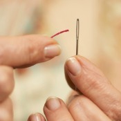 Woman Threading a Sewing Needle