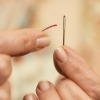 Woman Threading a Sewing Needle