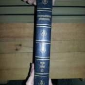Someone holding up a volume to show the spine of the book.