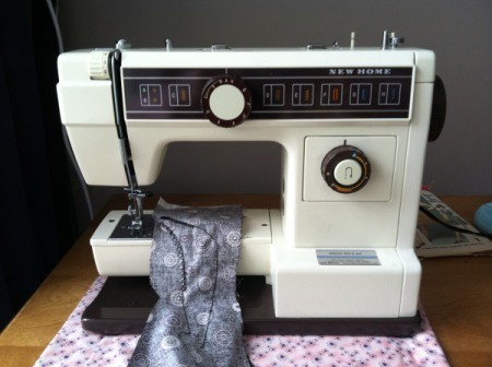 Sewing machine with a piece of fabric on the sewing platform.