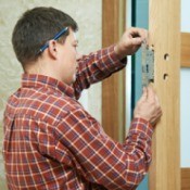 Man Replacing Deadbolt and Door Lock on Door