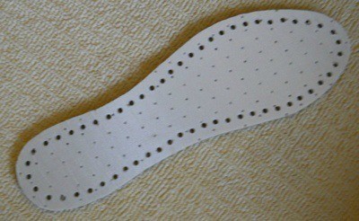 Inner sole with holes punched around outside edge.