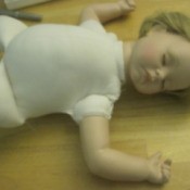 Baby doll lying on its back asleep.