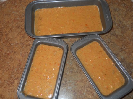 One large and two small loaf pans with uncooked batter.