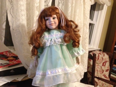 Red haired doll in frilly dress.