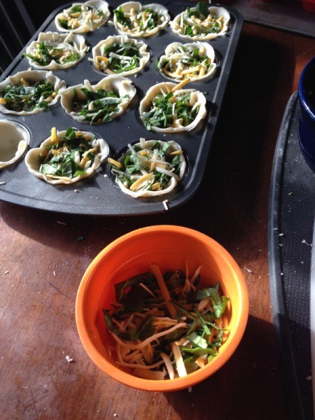 add spinach and cheese to muffin tin