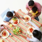 Family Eating Dinner on Table with Linen