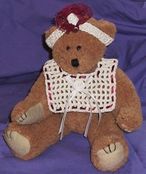 Teddy bear wearing bib and headband.
