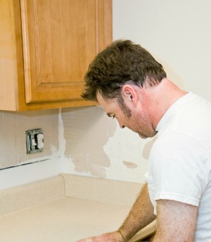 Man repairing kitchen countertops.