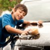 Young teen boy washing the car.