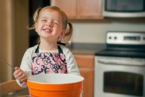 A young girl baking.