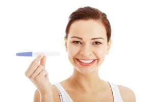 A woman holding a pregnancy test.