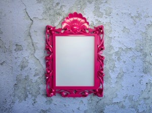 A picture frame on a plaster wall.