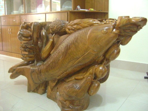 Wooden table base with fish and other details.