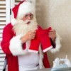 Santa looking at his pants that have been shrunk in the laundry.