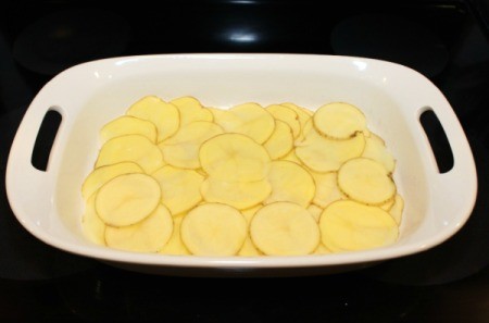 layer half of potatoes in pan