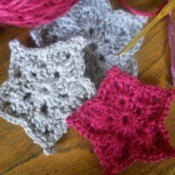 closeup of three finished stars with yarn and hooks