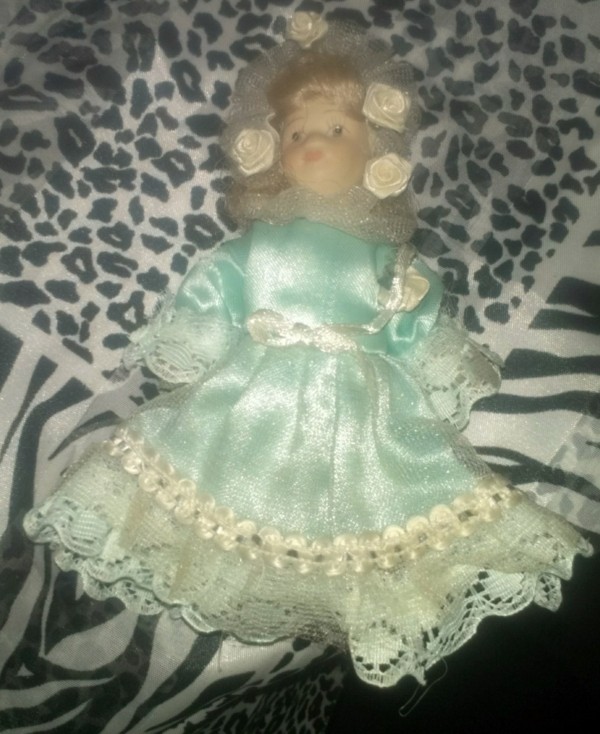 blond doll wearing a blue dress with lace ruffle