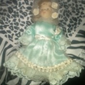 blond doll wearing a blue dress with lace ruffle