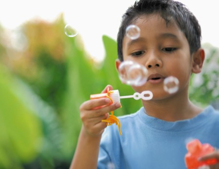 A boy blowing bubbles.