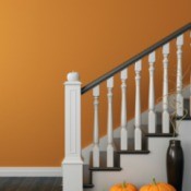 A staircase next to an orange painted wall.