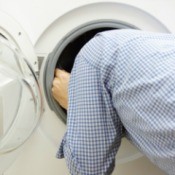 man with head inside front load washer