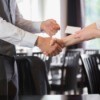 two people shaking hands and exchanging business cards