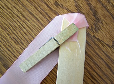 using clothes pin to hold ribbon for gluing to handle